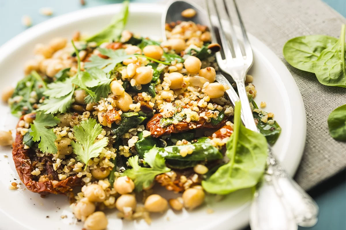 Salade végétarienne de semoule, pois chiches, tomates confites et épinards à la coriandre