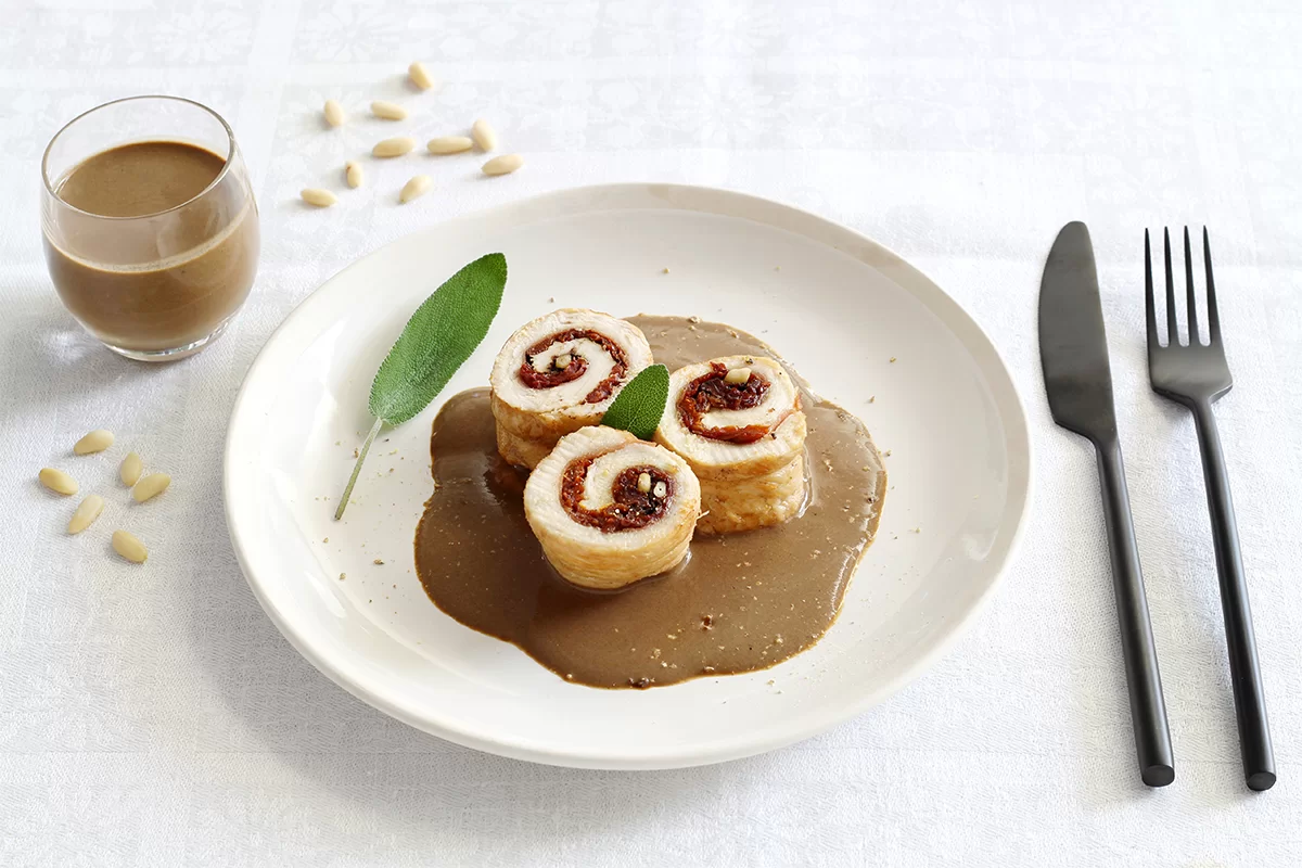 Roulades de dinde au jambon, pignons et tomates séchées en sauce de confit d'ail noir